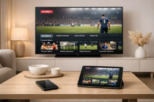 Salon moderne avec télévision connectée diffusant une interface de streaming sportif, accompagnée d’un smartphone et d’une tablette.